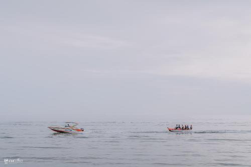 two boats in the water with people in them at Sand Dunes Chaolao Beach Resort in Chao Lao Beach