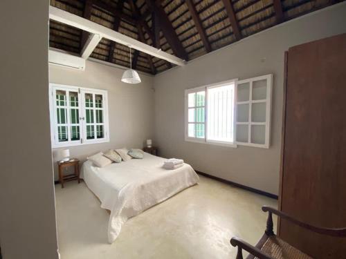 a bedroom with a white bed and two windows at La plage in Centre de Flacq