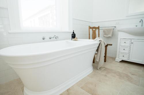 a white bath tub in a bathroom with a window at Old Market Inn in Port Fairy