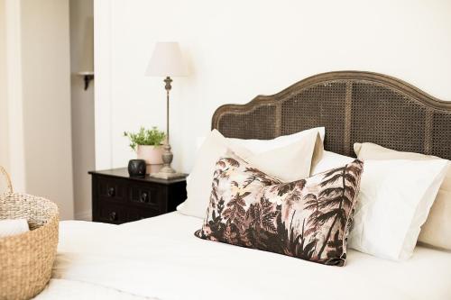 um quarto com uma cama com almofadas brancas em Old Market Inn em Port Fairy