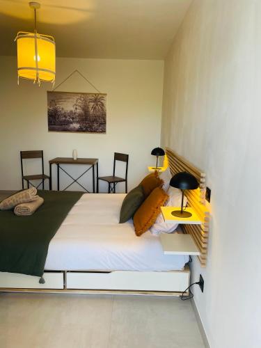 a bedroom with a bed and a desk with two lamps at Chambre d’hôtes in Saintes-Maries-de-la-Mer