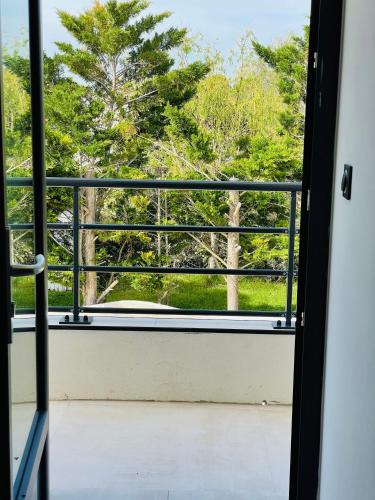 an open door to a balcony with a view of trees at Chambre d’hôtes in Saintes-Maries-de-la-Mer