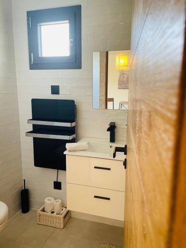 uma casa de banho com um lavatório e um espelho em Chambre d’hôtes em Saintes-Maries-de-la-Mer