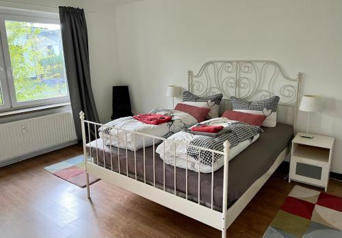 a bedroom with a white bed with red pillows at Ferienwohnung Nordlicht in Rostock