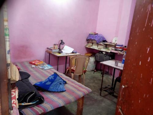 une petite chambre avec deux tables et deux bureaux dans l'établissement Laxmi boys Hostel By WB Inn, à Kanpur