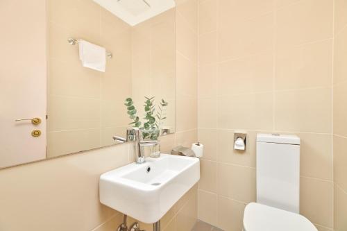 a bathroom with a sink and a toilet and a mirror at Hotel Zorna Plava Laguna in Poreč