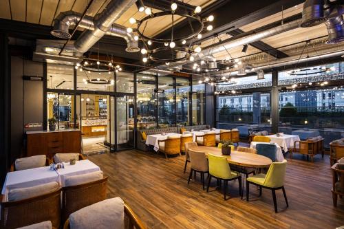 a restaurant with tables and chairs in a room at Movenpick Living Istanbul West in Istanbul