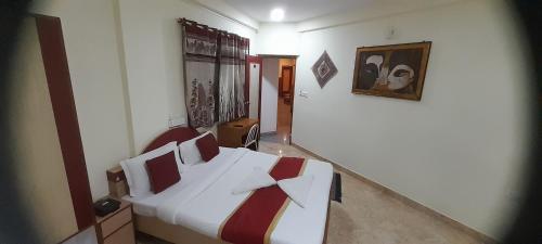 a bedroom with a bed and a painting on the wall at CTC GARDENIA RESIDENCY in Bangalore