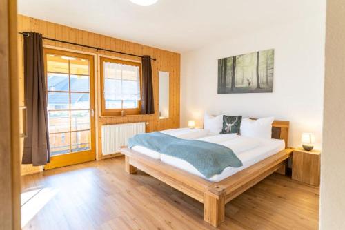 - une chambre avec un grand lit et une grande fenêtre dans l'établissement Finkenhof, à Schluchsee