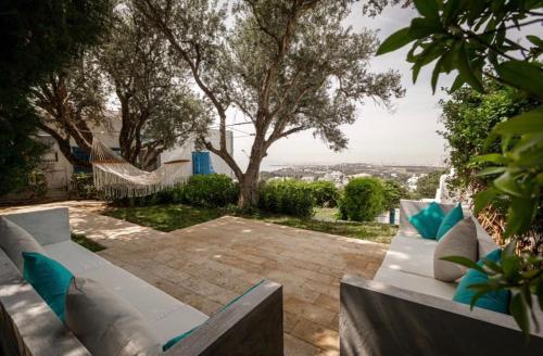 a white couch sitting on a patio with a hammock at La Villa Des Oliviers in Sidi Bou Saïd