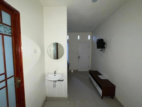 Baño blanco con lavabo y espejo en Bromo Semesta Guesthouse en Probolinggo