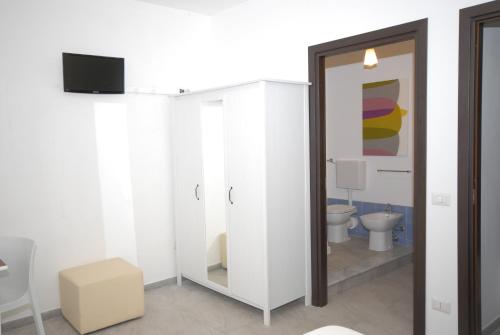 a bathroom with a toilet and a television in it at Casa Helios in Castellammare del Golfo