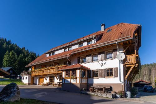 a large wooden building with a red roof at Finkenhof in Schluchsee
