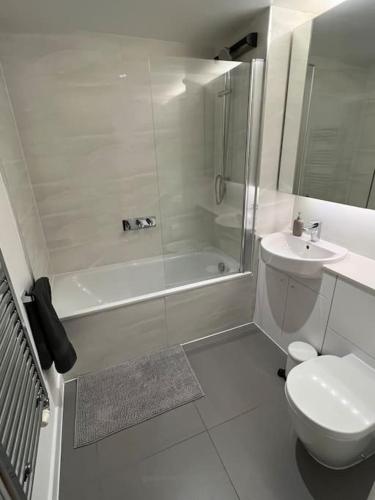 a white bathroom with a toilet and a sink at Modern 2 bed - Olympic Park Stratford in London