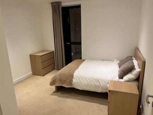 a bedroom with a bed and a dresser and a mirror at Modern 2 bed - Olympic Park Stratford in London