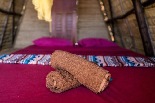 a brown towel laying on top of a bed at Young Wild and Free in Koh Kong