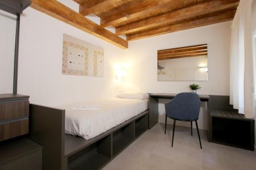 a bedroom with a bed and a desk and a chair at Residence Modern Art in Venice