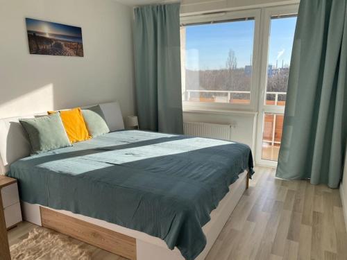 a bedroom with a bed and a large window at Self check in with parking included in Bratislava