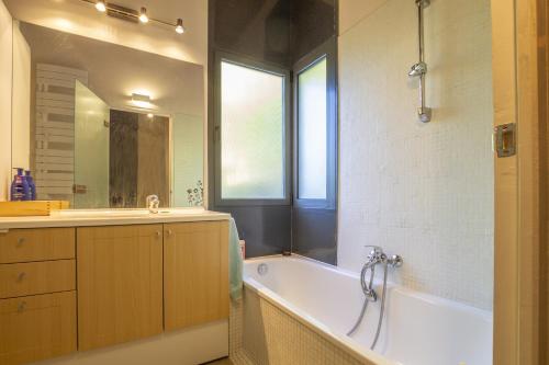 a bathroom with a tub and a sink and a bath tub at La Maison des Chataigniers in Meyrannes