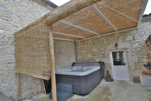 a large outdoor bath tub in a stone building at Chambre d'hôtes Le Bol d'Air avec jacuzzi in Castelnau-sur-lʼAuvignon