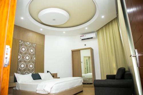 1 dormitorio con cama blanca y techo en SAJ Farm Inn en Ibrā