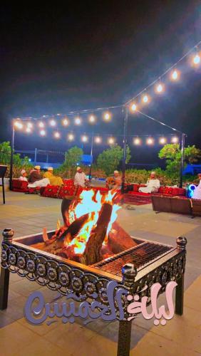 a fire pit in a park at night at SAJ Farm Inn in Ibrā