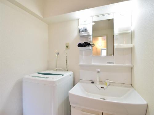 a bathroom with a sink and a toilet and a mirror at Urban Life Matsuda - Vacation STAY 85183 in Okayama