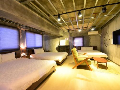 a room with two beds and a chair in it at Urban Life Matsuda - Vacation STAY 85183 in Okayama