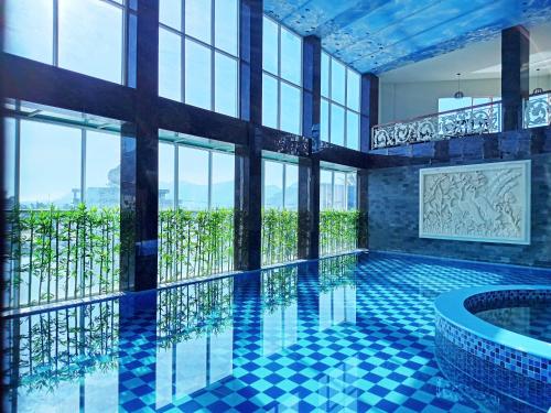 a swimming pool in a building with windows at Grand Bayu Hill Hotel in Takengon