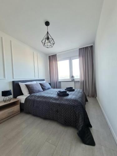 a bedroom with a bed and a large window at Sun and holidays apartament Władysława IV in Gdynia