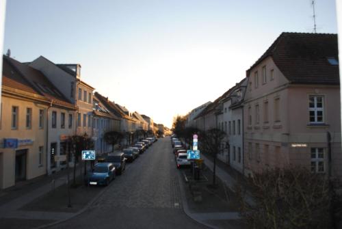 a street with cars parked on the side of the road at Stadtblick Neuruppin in Neuruppin