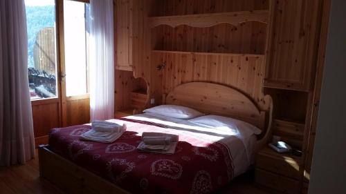 una camera da letto con un letto e due asciugamani di Albergo Bellavista a Comèlico Superiore