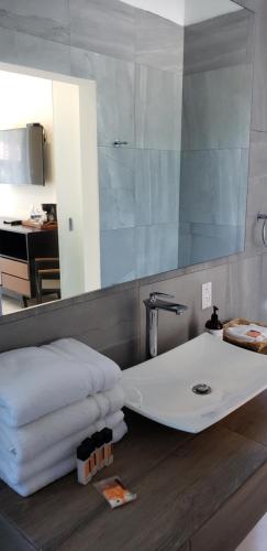 a bathroom with a sink and a mirror and towels at Hotel CaLu 2 en La Laguna, Santa María del Oro in Santa María del Oro