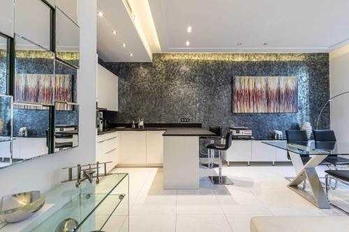 une cuisine avec des armoires blanches et une table avec des chaises dans l'établissement Large renovated studio - rue Hoche - Cannes center, à Cannes