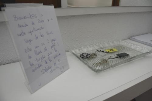 un escritorio con una hoja de papel y una caja con una nota en Apartamento Virgen de las Viñas, en Aranda de Duero
