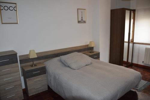 ein Schlafzimmer mit einem Bett, zwei Kommoden und einem Fenster in der Unterkunft Apartamento Virgen de las Viñas in Aranda de Duero