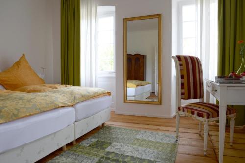 a bedroom with a bed and a mirror and a desk at Alte Apotheke Bed & Breakfast in Karlsbad