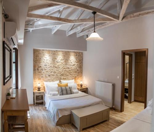 a bedroom with a large bed and a stone wall at Roptro in Doliana