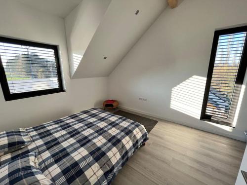 a bedroom with two windows and a bed in it at Inviting 4-Bed House in Berdorf Luxemburg in Berdorf