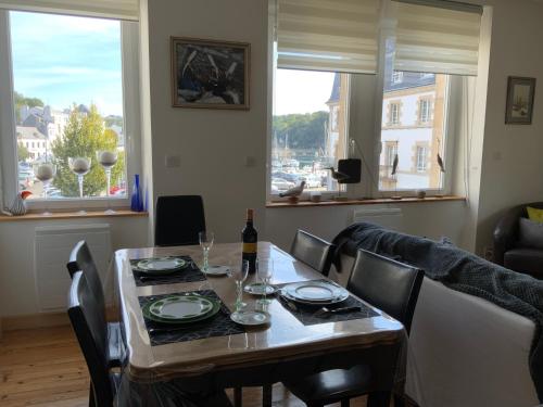una sala da pranzo con tavolo e bottiglia di vino di Appartement de charme - Port d'Audierne ad Audierne