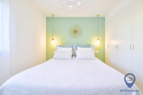 a bedroom with a large bed with white sheets at Apartamento Ohana by MTPhomes in Armação de Pêra