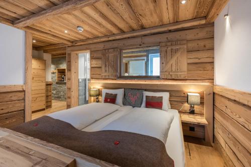 1 dormitorio con 1 cama grande en una habitación con paredes de madera en Hotel Crusch Alba Zernez, en Zernez