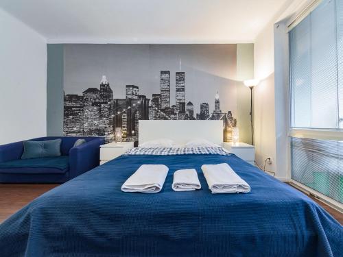 a bedroom with a blue bed with two towels on it at Nowogrodzka Cozy Studio II in Warsaw