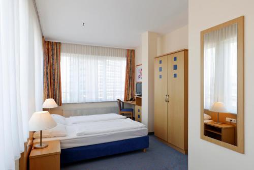 a hotel room with a bed and a window at Hotel Plaza Hannover in Hannover