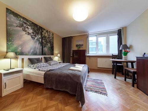 a bedroom with a bed and a large painting on the wall at Sliska 10 apartament in Warsaw