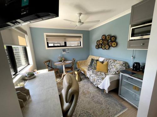 uma sala de estar com um sofá e uma mesa em New & adorable unit close to the beach em Aspendale