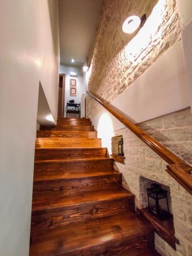 a staircase in a house with wooden floors and a stone wall at Roptro in Doliana