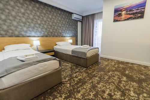 um quarto de hotel com duas camas e um quadro na parede em Solay em Oradea