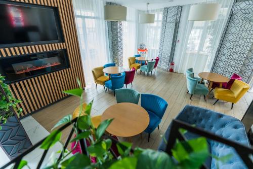 a living room with tables and chairs and a tv at Solay in Oradea