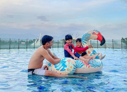 a family sitting on an inflatable duck in the water at Crowne Plaza Bandung by IHG in Bandung